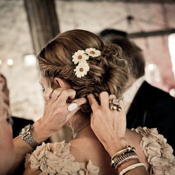 Close-up of hairstyling for a bride with floral accents, creating an elegant wedding look.